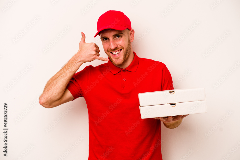 Young delivery caucasian man holding pizzas isolated on white background showing a mobile phone call gesture with fingers. Young delivery caucasian man holding pizzas isolated on white background showing a mobile phone call gesture with fingers.