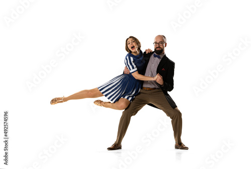 Couple of dancers, young man and woman in vintage retro style outfits dancing swing dance isolated on white background. Timeless traditions, 60s, 70s fashion style.