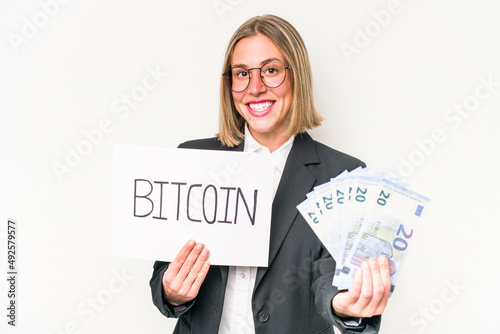 Young caucasian business woman holding bitcoin placard and banknotes isolated on white background