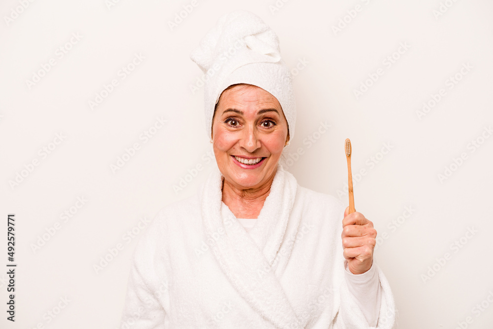 Middle age caucasian woman wearing a bathrobe holding toothbrush isolated on white background happy, smiling and cheerful. Middle age caucasian woman wearing a bathrobe holding toothbrush isolated on white background happy, smiling and cheerful.