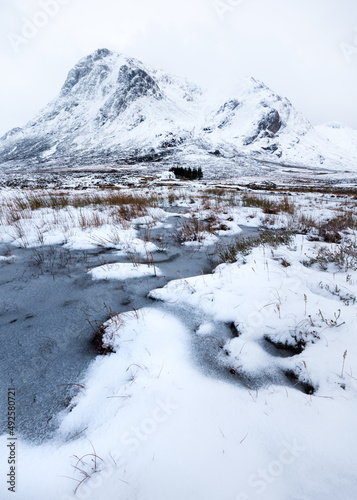 View of famous Lagangarbh Hut with Scottish mountains in background covered in snow. Glencoe  Scotland  UK. 