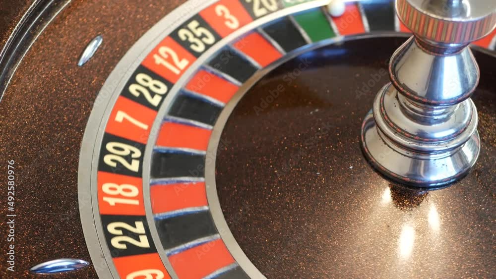 Ball on wooden french roulette table in casino. Wheel spinning, turning or rotating. Odd and even numbers, black, red and zero sectors. Bets in game of chance. Money playing, gambling or risky betting Ball on wooden french roulette table in casino. Wheel spinning, turning or rotating. Odd and even numbers, black, red and zero sectors. Bets in game of chance. Money playing, gambling or risky betting