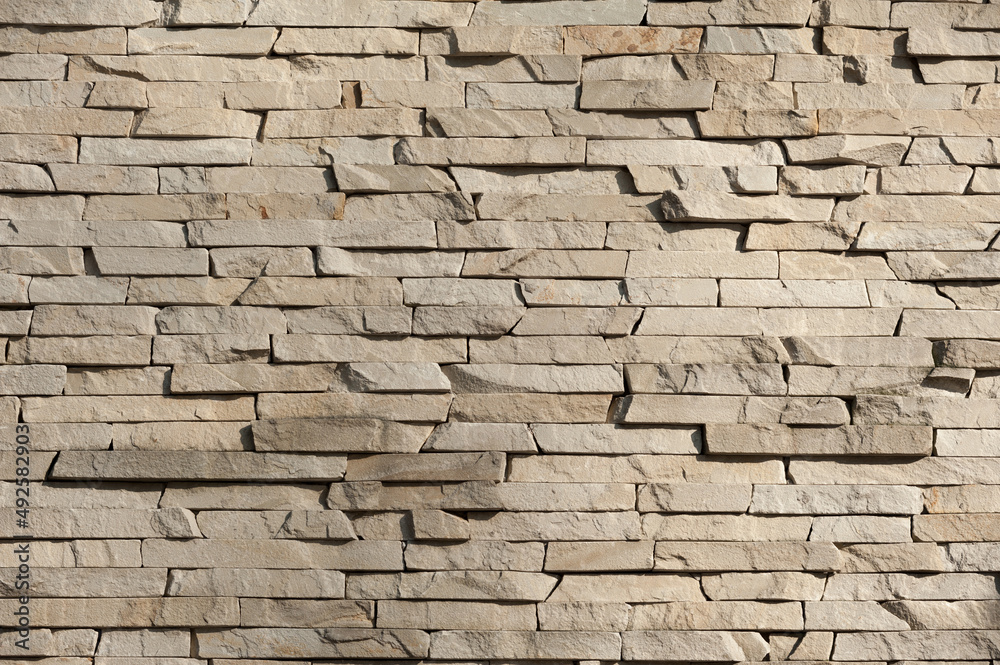 A wall surface with a natural stone texture. The pattern of a stone tiles background A wall surface with a natural stone texture. The pattern of a stone tiles background