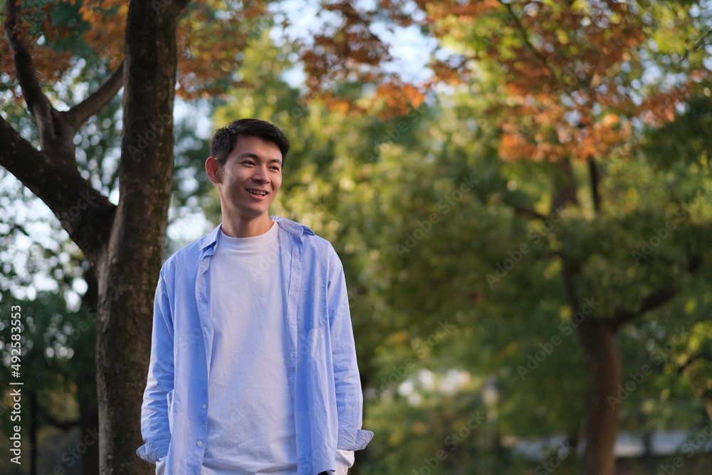 smiling handsome Asian young man at forest in autumn smiling handsome Asian young man at forest in autumn
