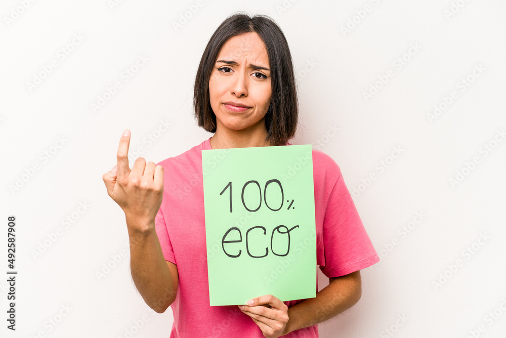 Young hispanic woman holding 100% eco placard isolated on white background pointing with finger at you as if inviting come closer. Young hispanic woman holding 100% eco placard isolated on white background pointing with finger at you as if inviting come closer.