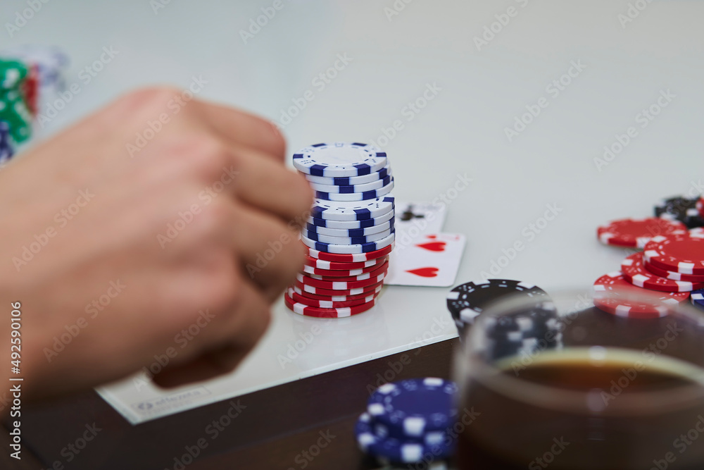 Poker game with chips, cards on the table. Glass of whiskey. Enjoying the moment, digital detox with friends. Lifestyle photography. Candid moment. Copy space. Selective focus.