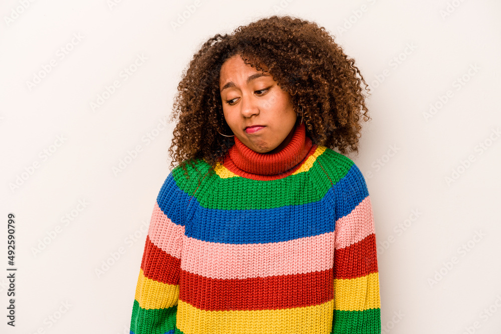 Young African American woman isolated on white background shrugs shoulders and open eyes confused. Young African American woman isolated on white background shrugs shoulders and open eyes confused.
