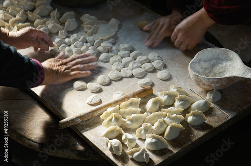 Making traditional dim sum Chinese dumplings. Meat dough pastry and spring onions cuisine. Farm kitchen Shandong Province, China photo