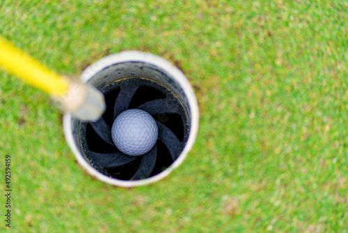 Golf ball in hole of cup at golf court