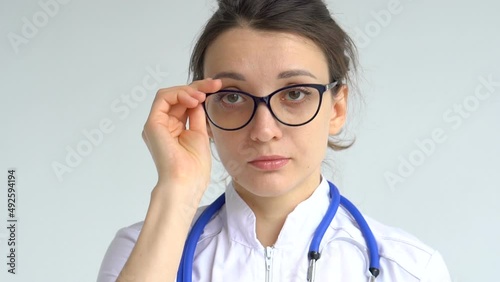 Female doctor is putting off protective blue gloves isolated on white background after some medical manipulations, vaccination.