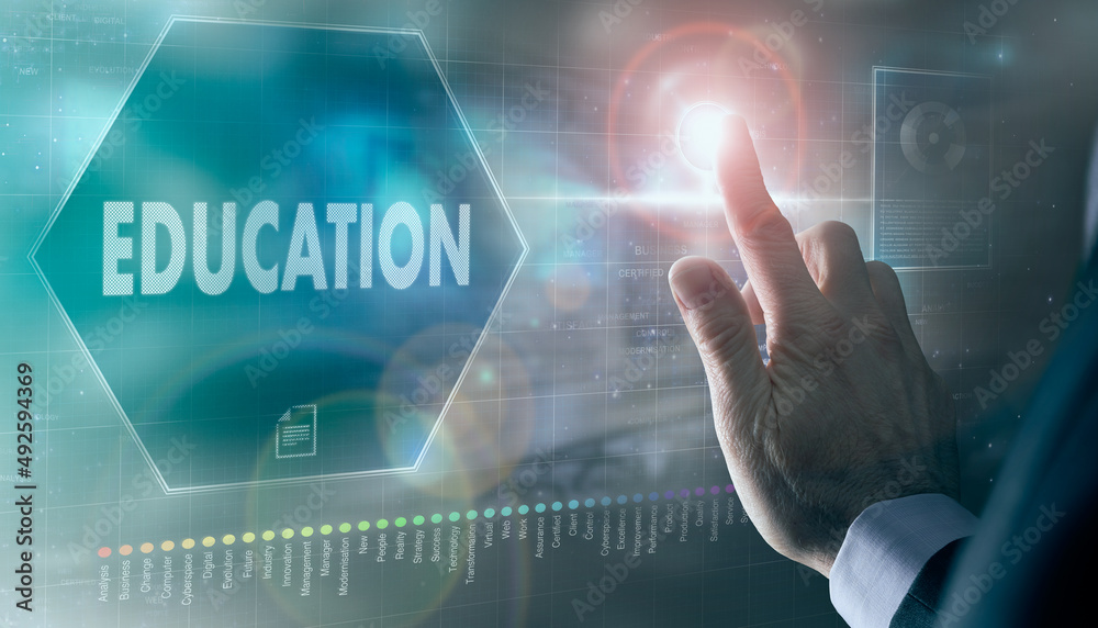 A businessman controlling a futuristic display with a Education business concept on it.