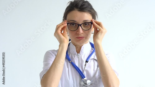 Female doctor is putting off protective blue gloves isolated on white background after some medical manipulations, vaccination.
