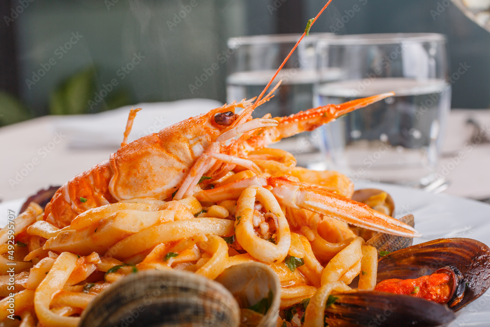 Piatto si Scialatielli ai frutti di mare con cozze, vongole, scampi, seppie e prezzemolo servito in un ristorante elegante Piatto si Scialatielli ai frutti di mare con cozze, vongole, scampi, seppie e prezzemolo servito in un ristorante elegante