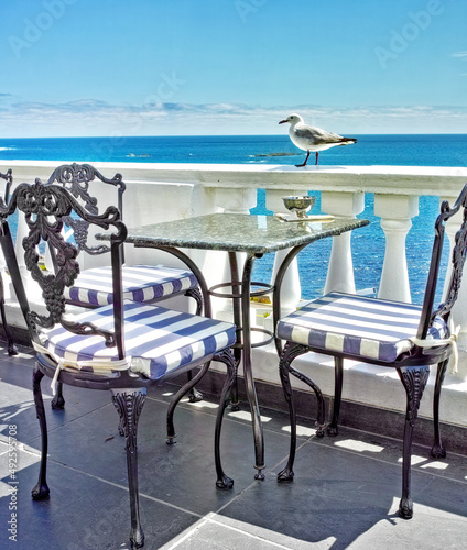 Vacation at the shore. Tables and chairs on the balcony of a seaside restaurant. photo