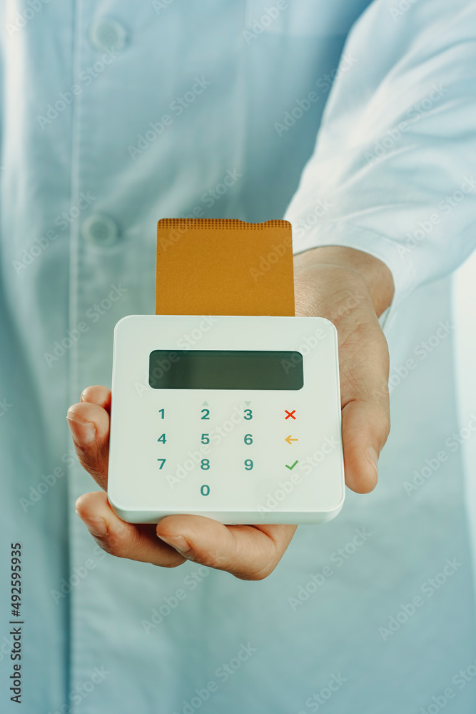 doctor holds a payment terminal with a credit card doctor holds a payment terminal with a credit card