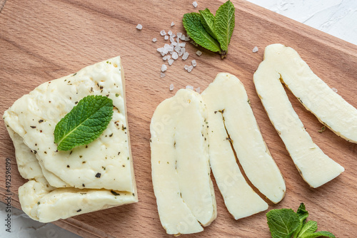 Grilled slices of halloumi cheese with grill marks and mint. Cyprus squeaky cheese with mint and almonds on a wooden board. banner, menu, recipe place for text, top view photo