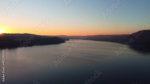 Aerial dron view of lake, water and silhouette of trees during sunset. Evening nature, beautiful landscape. FullHD footage