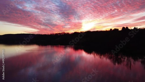 Aerial dron view of lake, water and silhouette of trees during sunset. Evening nature, beautiful landscape. FullHD footage