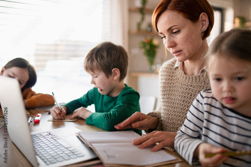 Mother of little children working on laptop when distance learning and doing artwork at home. Mother of little children working on laptop when distance learning and doing artwork at home.