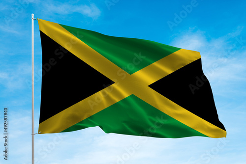 Jamaica flag waving in the blue sky