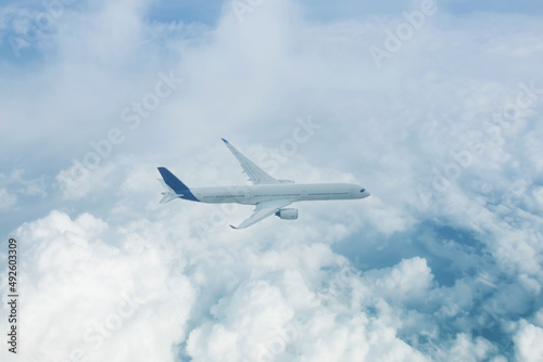 Passenger plane flies high above the clouds aerial view.