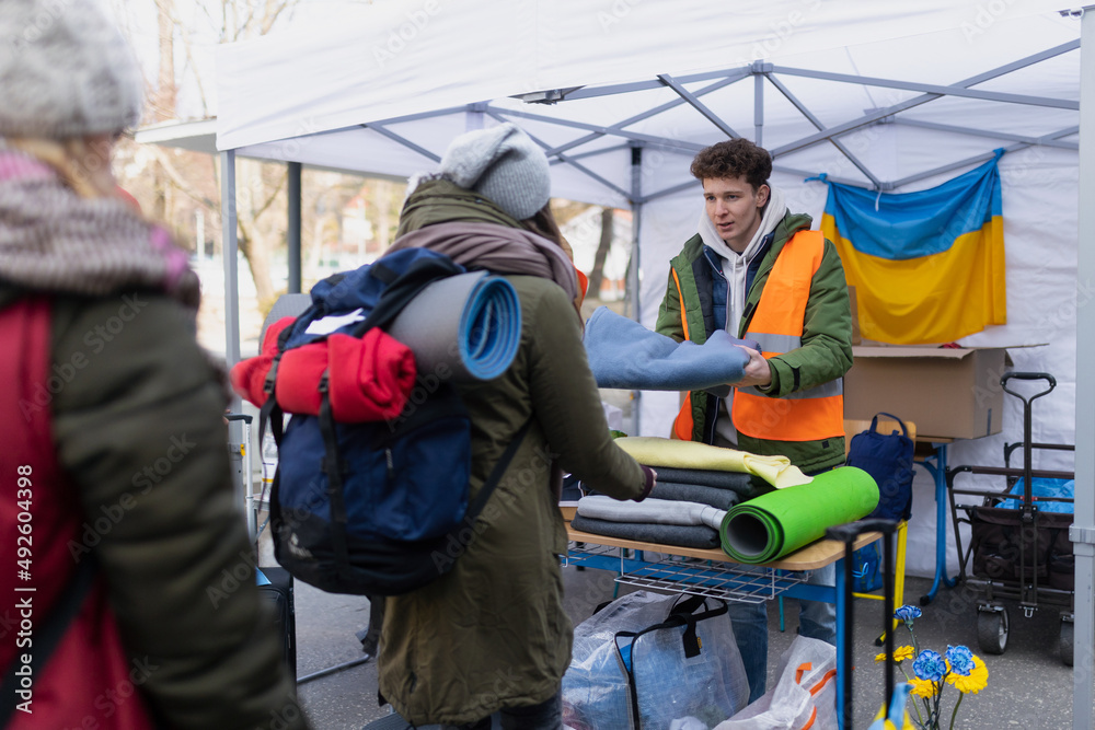 Fototapeta premium Volunteers distributing blankets and other donations to refugees on the Ukrainian border.