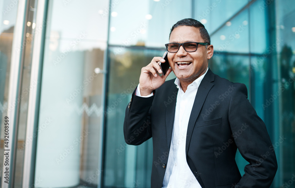 Ive just stepped out. Cropped shot of a handsome mature businessman making a phonecall with his office in the background. Ive just stepped out. Cropped shot of a handsome mature businessman making a phonecall with his office in the background.