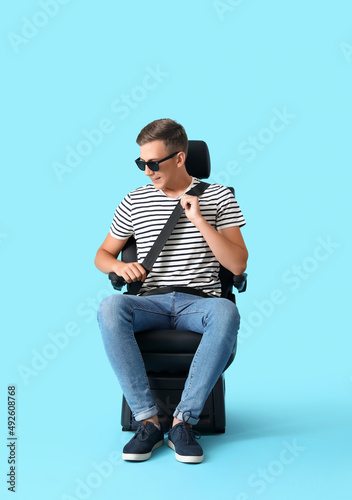 Man in car seat on color ba...