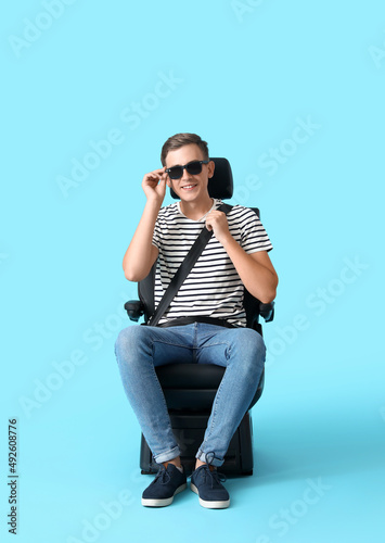 Man in car seat on color ba...