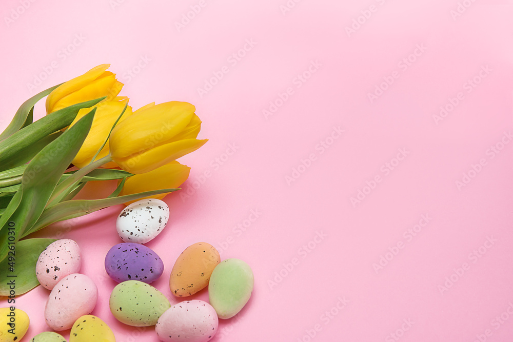 Easter colorful eggs on a pink background with a bouquet of yellow tulips, Easter card with space for text Easter colorful eggs on a pink background with a bouquet of yellow tulips, Easter card with space for text