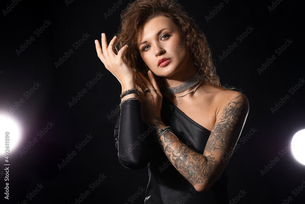 Beautiful fashionable tattooed woman on black background Beautiful fashionable tattooed woman on black background