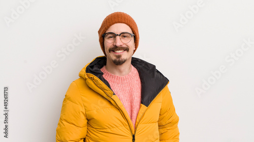 young handsome man with a coat against white wall photo