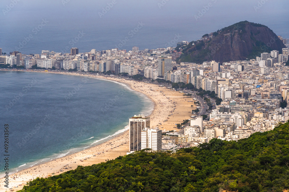 Aerial view of Copacabana beach with its buildings, sea and landscape. Huge hills along the entire length. Immensity of the city of Rio de Janeiro, Brazil in the background