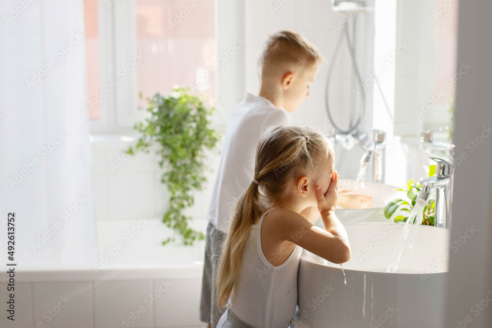 Children brother and sister wash and brush their teeth in the bathroom Children brother and sister wash and brush their teeth in the bathroom