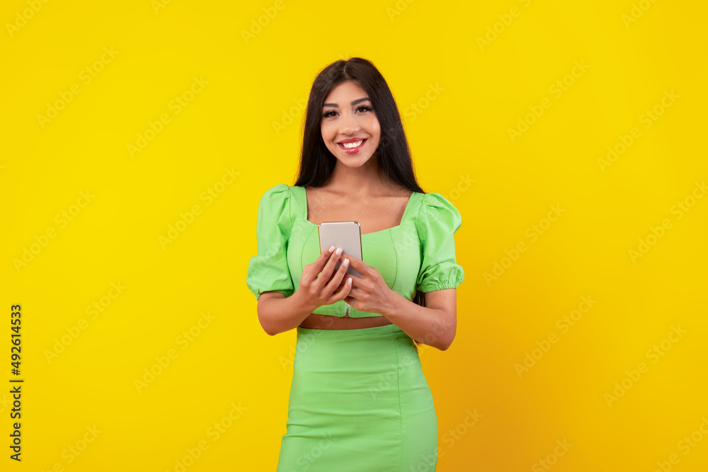Happy young woman using cell phone at studio Happy young woman using cell phone at studio