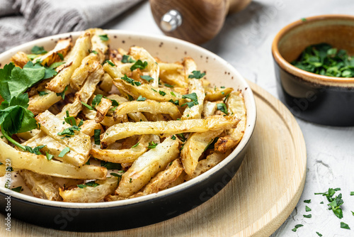 Roasted Parsnips on light Background. side dish on plate. Delicious vegetarian breakfast or snack, Clean eating, dieting, vegan food concept. top view