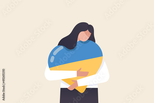 The girl hugs a heart with the colors of the flag of Ukraine. "stay with Ukraine" concept.