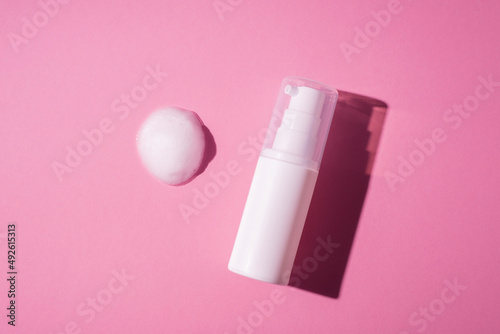 Bilde på lerret Plastic white bottle with pump and the appearance of the texture of the foam on a pink background
