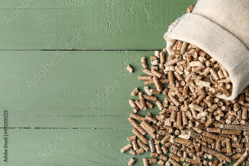 Fotografía Sack bag of wood pellets on color wooden background