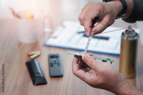 Fotografía Close up hand an electronic service man cleaning and check what's wrong with the