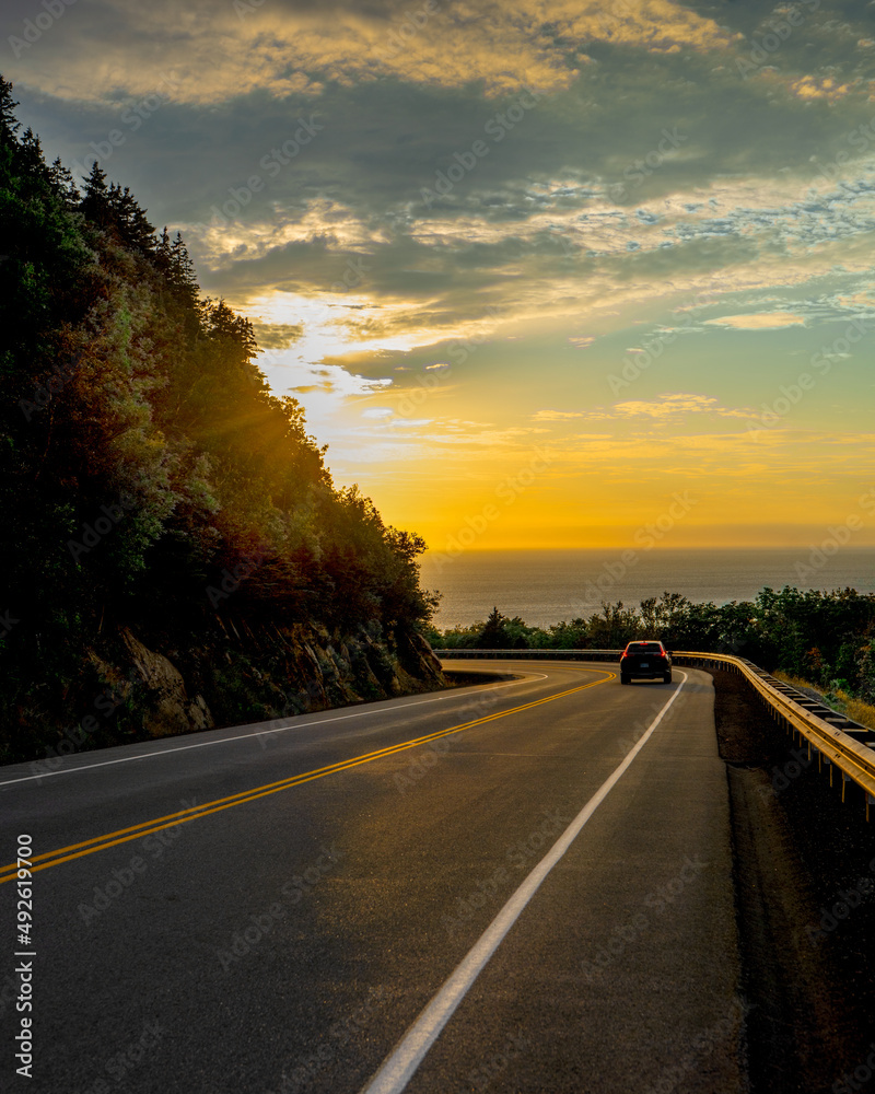 Sunset at Cabot trail in Cape Breton, Canada. Winding roads, by the Atlantic Ocean coastline.
