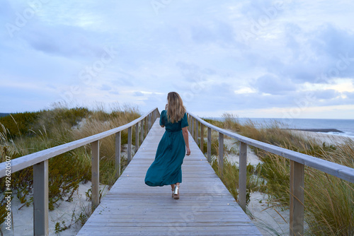 elegant woman walking along a walkway in front of the sea photo