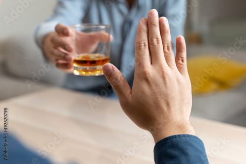 person deny alcohol drink from his friend photo