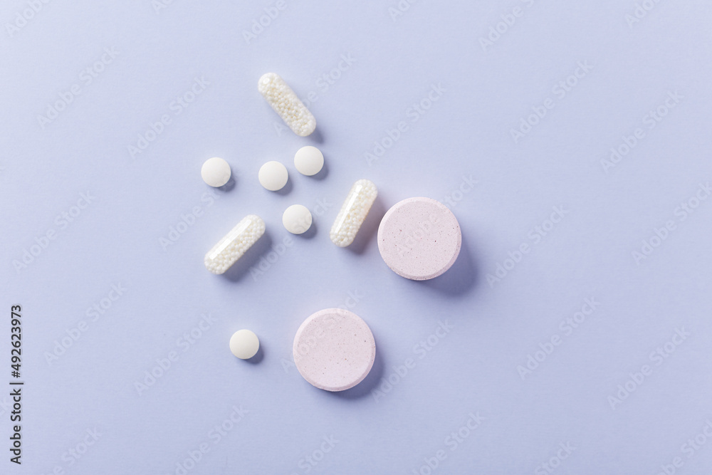 Collagen effervescent Tablets and Vitamin C tablets and capsules. Supplements to support collagen production. Bright paper background. Top view. Close up. Copy space. Collagen effervescent Tablets and Vitamin C tablets and capsules. Supplements to support collagen production. Bright paper background. Top view. Close up. Copy space.