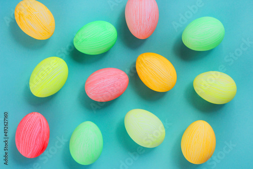 multi-colored eggs in pastel tones on a green background. Easter decor. top view.
