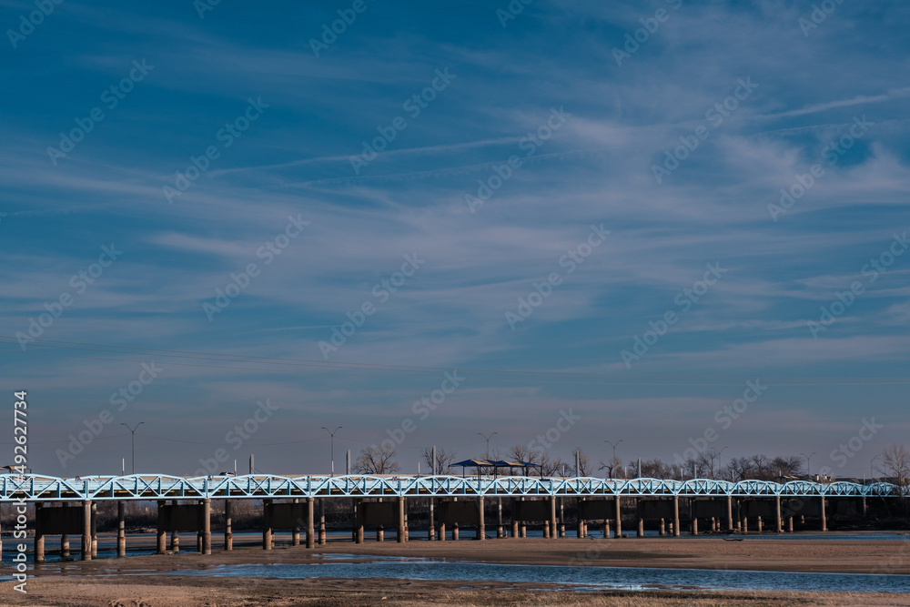 Blue sky over a blue pedestrian bridge