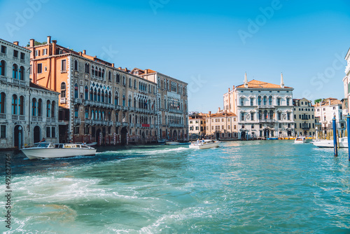 Italian landscape of picturesque horizontal scenery of small motor boats during getaway travel trip to Venice with crystal clear water of Grand Canal, concept of tourism and international vacations