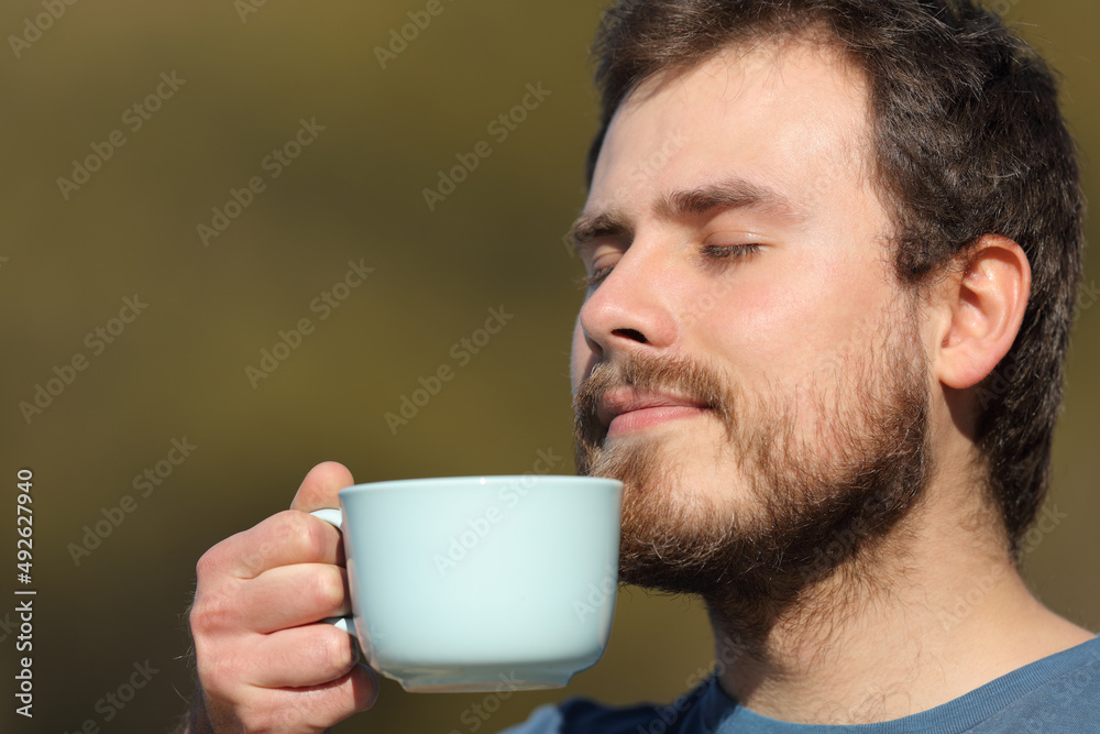 Man smelling coffee aroma outdoors Man smelling coffee aroma outdoors