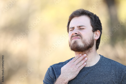 Man suffering sore throat in nature
