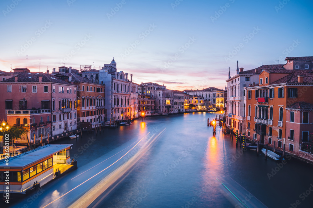 Filtred scenery landscape with lights on water of Grand Canal during evening time for romantic sightseeing in Venezia, overview of ancient architecture buildings during international vacations Filtred scenery landscape with lights on water of Grand Canal during evening time for romantic sightseeing in Venezia, overview of ancient architecture buildings during international vacations